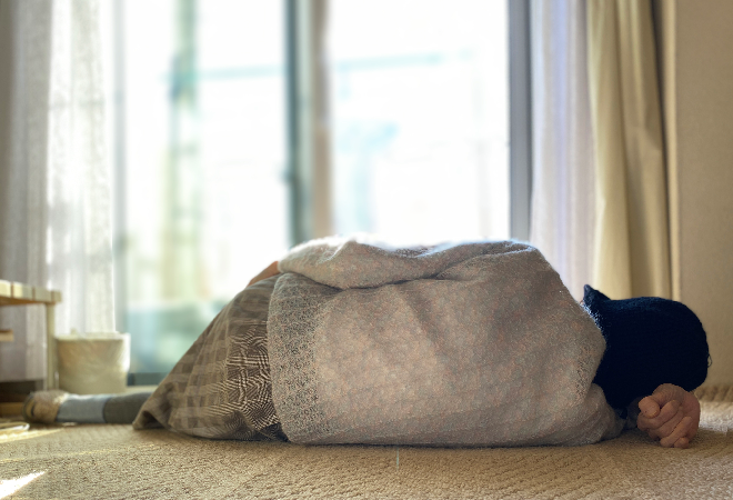 横になっている高齢者の後ろ姿。