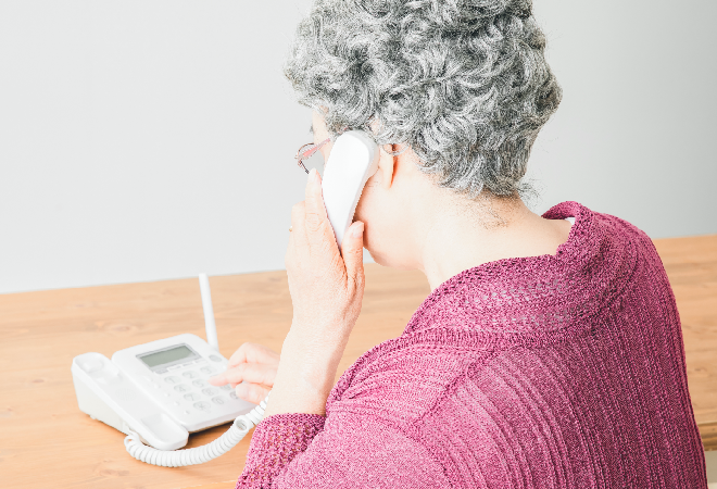 電話をする高齢女性の後ろ姿。