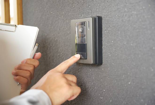 インターホンを押す業者の手元。